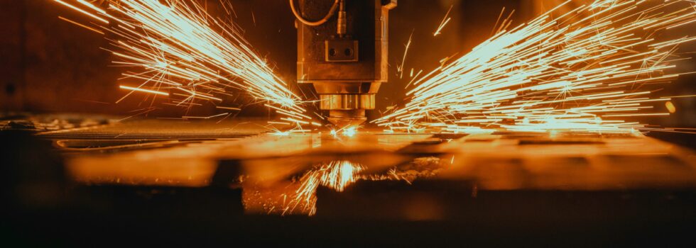 CNC-Fräsmaschine bei der Arbeit, Funken sprühen während der präzisen Bearbeitung eines Werkstücks.