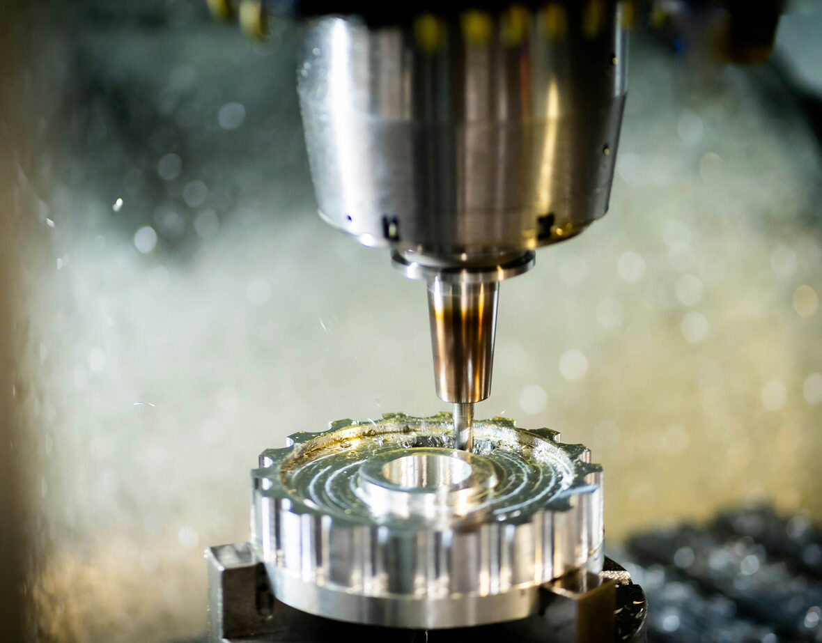 Nahaufnahme einer CNC-Fräse bei der präzisen Bearbeitung eines Werkstücks. Die Maschine arbeitet mit hoher Genauigkeit und Effizienz.