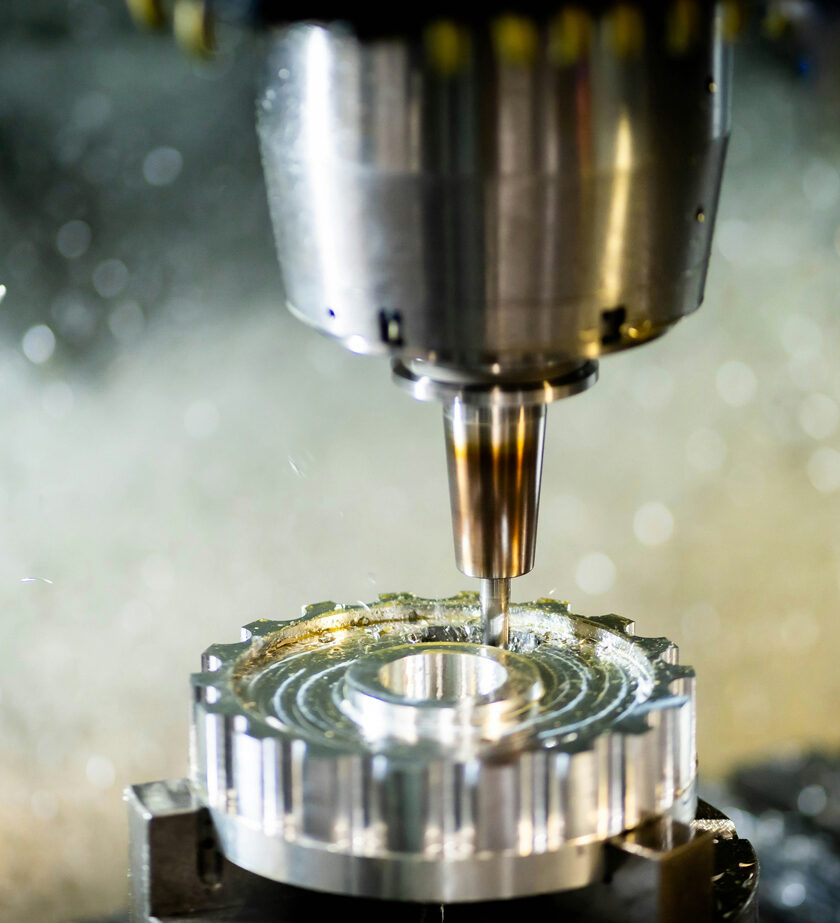 Nahaufnahme einer CNC-Fräse bei der präzisen Bearbeitung eines Werkstücks. Die Maschine arbeitet mit hoher Genauigkeit und Effizienz.